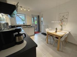 a kitchen and dining room with a table and chairs at Blauer Blick 12 in Laboe