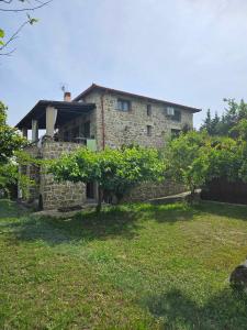 a stone house with a yard in front of it at Stone Villas in Nea Roda