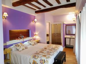 a bedroom with purple walls and a large bed at Casa Rural Los Carros in San Asensio