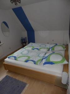 ラーボエにあるFewo Lerchenstraßeのベッドルーム1室(青と緑の掛け布団付きのベッド1台付)