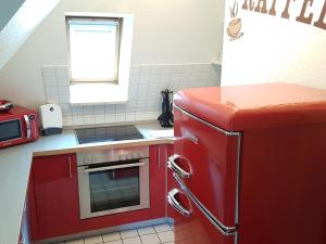 cocina con nevera roja y microondas en Wiesenweg W17 en Laboe