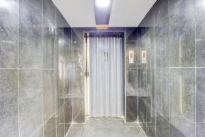 uma casa de banho com um chuveiro e uma porta de vidro em OYO Sam Guest House em Chennai