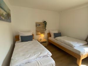 2 camas en una habitación pequeña con lámpara en Fewo Mundt Laboe, en Laboe