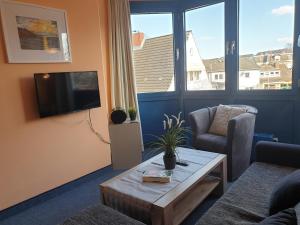 a living room with a couch and a table and a tv at Fewo Panorama 14 in Laboe