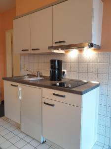 a kitchen with white cabinets and a sink at Fewo Panorama 14 in Laboe