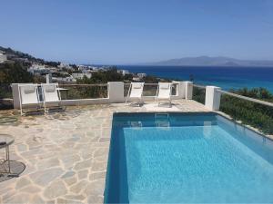 a swimming pool with chairs and a view of the ocean at Villa Irenes Dream - For dreamy holidays in Mikri Vigla