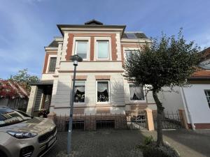a house with a car parked in front of it at FeWo Lohmann in Laboe