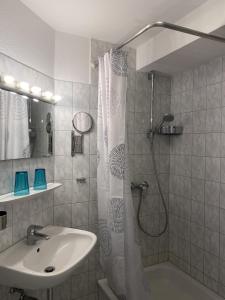 a bathroom with a sink and a shower with a shower curtain at Nautic W22 in Laboe