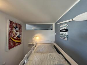 a small bedroom with a bed and signs on the wall at Meerblickbude in Wendtorf