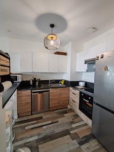 a kitchen with white cabinets and a stainless steel refrigerator at Garden Atlantide Promenade in Nice
