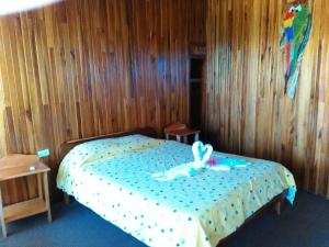una camera da letto con un letto con un coniglio sopra di Hotel El Atardecer a Monteverde Costa Rica