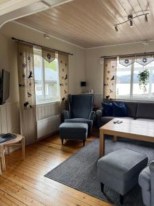 a living room with a couch and chairs and windows at Villa Skoganvarre in Skoganvarre