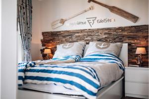 a bed with blue and white striped blankets and pillows at EdelStein in Stein