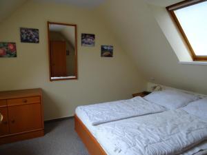 a bedroom with a bed and a mirror and a window at Kapitänshaus W18 C in Laboe +5 photos