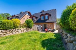 una casa con una valla de piedra y un patio en Senmare, en Munkmarsch