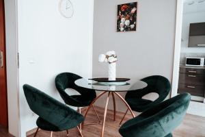a dining room with a table and green chairs at Ferienwohnung Ella - direkt am Bodensee in Friedrichshafen
