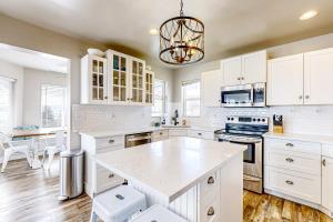 eine Küche mit weißen Schränken und einem Tisch darin in der Unterkunft Buttercup Beauty in Garden City