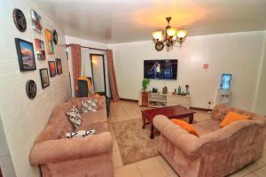 a living room with two couches and a table at Magazi suites 3 in Nairobi