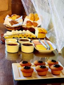 una mesa con una bandeja de bollería y otros alimentos en Pousada Solar Azul, en Lençóis