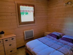 una camera da letto con un letto e una finestra di Chalet des platanes Entre l'Alsace et les Vosges Nature a La Grande Fosse
