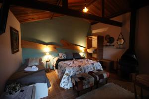 a bedroom with a bed and a couch in a room at Pousada e Chalés Vista Linda in Santo Antônio do Pinhal