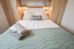a bed with a blanket and towels on it at Ferienhaus Ostseechalet Strandmuschel Gelting in Gelting