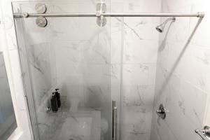 a bathroom with a shower with a glass door at Newly Renovated - Minutes from the City in Woodside +7 photos