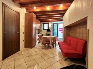 代森扎诺-德尔加达Nido tra castello e lago的客厅里有一张红色沙发和一张桌子。