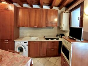 a kitchen with wooden cabinets and a stove top oven at Nido tra castello e lago in Desenzano del Garda