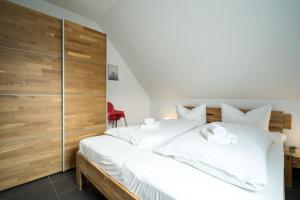 MarienfeldeにあるFerienwohung Müritzfreude OGの白いベッド1台が備わる木製の壁のベッドルーム1室