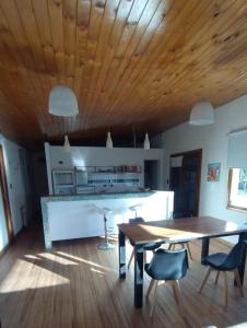 ein Wohnzimmer mit einer Holzdecke sowie einem Tisch und Stühlen in der Unterkunft LAS LAVANDAS in Sierra de la Ventana