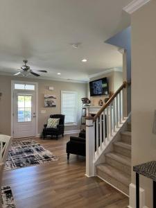 a living room with a staircase with a couch and a chair at Sparrows Nest 3br 2 and half bath beach cottage in Beaufort