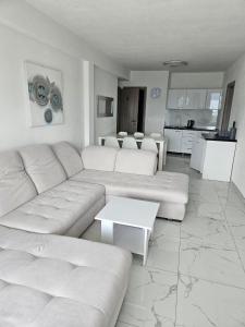 een woonkamer met een witte bank en een keuken bij Villa Anamaria in Lokva Rogoznica