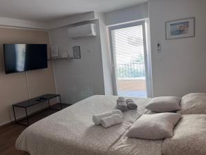 a bedroom with a bed with two pillows and a television at Olea Rooms Piran Old Town in Piran