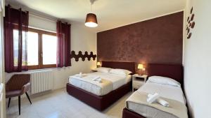 una camera d'albergo con due letti e una sedia di Agriturismo Colle Maiano a Vietri