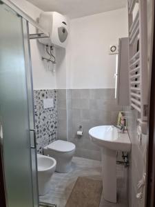 a white bathroom with a toilet and a sink at Dimore Rosantò in Palombaro