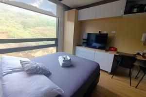 a bedroom with a bed and a desk and a television at Loft Ejecutivo, vista panorámica, Usaquén Bogotá in Bogotá