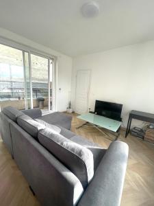 sala de estar con sofá y TV en DUPLEIX PARISIEN en Vanves