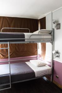 2 łóżka piętrowe w pokoju wieloosobowym z materacem w obiekcie GUANAKO Hostel w mieście Santiago