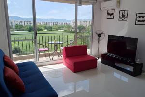 a living room with a red chair and a television at Relax con excelente vista, Ricaurte Peñalisa in Ricaurte