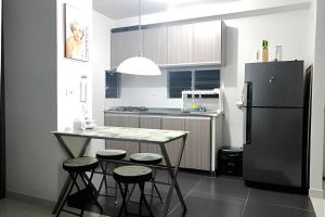 a kitchen with a black refrigerator and a table and stools at AH/ Relax con vista natural, Peñalisa Ricaurte in Ricaurte