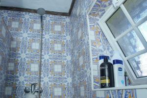 a bottle of wine on a shelf next to a tile wall at Casa da Avó Madalena in Fayal da Terra +16 photos