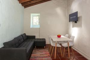 a living room with a couch and a table at Casa da Avó Madalena in Fayal da Terra