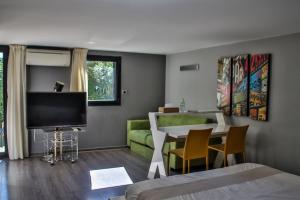 a bedroom with a living room with a couch and a television at Villa d'exception au Beausset avec piscine chauffée in Le Beausset