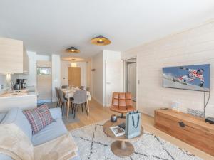 a living room with a blue couch and a kitchen at Appartement 2 pièces - Centre Vieil Alpe, parking inclus - FR-1-645-59 in LʼHuez