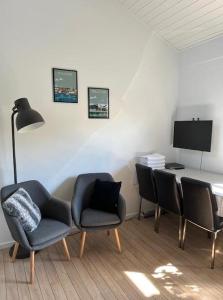 a living room with chairs and a table with a television at Driverhuset B&B in Grindsted