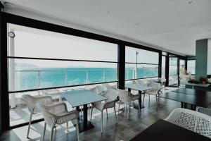 restauracja ze stołami i krzesłami oraz oceanem w obiekcie Grand Mirage we Wlorze