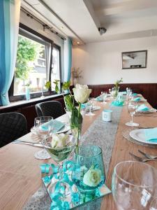 una mesa larga con vasos y flores. en Gasthaus "Zur frischen Quelle", en Laubach