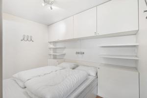 ein weißes Zimmer mit einem Bett und weißen Schränken in der Unterkunft Voss Resort Bavallstunet in Skulestadmo