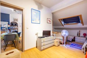 1 dormitorio con cuna y escritorio con ordenador en Magnifique petit appartement tout équipé, silencieux en Anhée